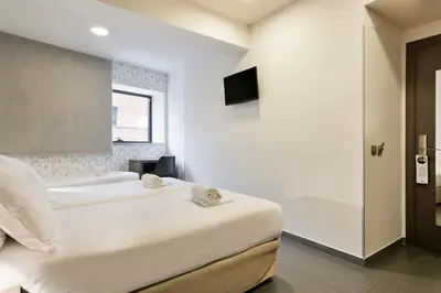 a bedroom with two beds and a bath tub at Hotel Acta Laumon in Barcelona