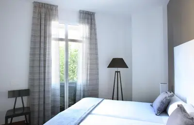 a bedroom with a bed and a window at MH Apartments Suites in Barcelona