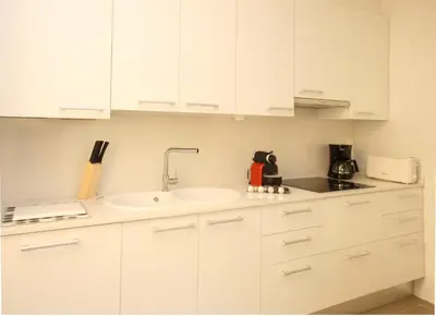 a kitchen with white cabinets and a sink at MH Apartments Suites in Barcelona