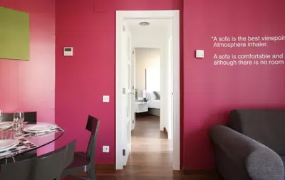 a dining room with pink walls and a table and chairs at MH Apartments Suites in Barcelona