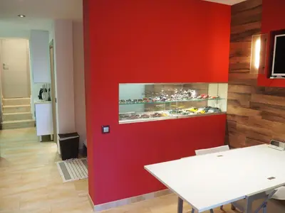 a room with a red wall with a display of food at apartamento aislado jardín y piscina in Sant Andreu de Llavaneres