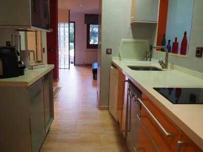 a dining room with a white table and chairs and a tv at apartamento aislado jardín y piscina in Sant Andreu de Llavaneres