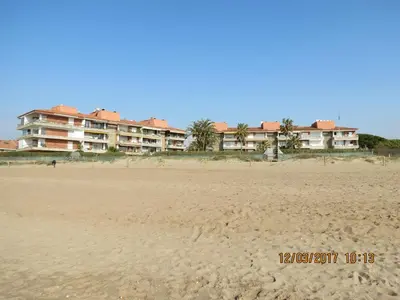 a beach with a large building in the background at GAVA 2 BEACHFRONT PENTHOUSE in Gavà