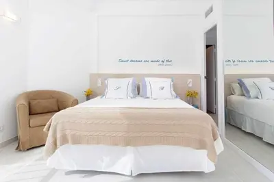 a bedroom with a large bed and a chair at Sitges Bellavista · Vistas Espectaculares del Mar in Sitges