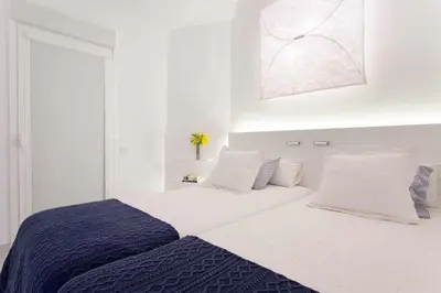 a white bedroom with a large bed with white pillows at Sitges Bellavista · Vistas Espectaculares del Mar in Sitges