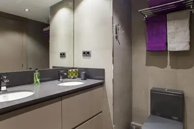 a bathroom with two sinks and a mirror and purple towels at Elegant Eixample Apartment nicely decorated in Barcelona