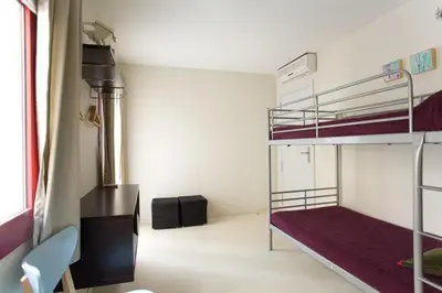a room with two bunk beds and a desk at Old City Beach House in Barcelona