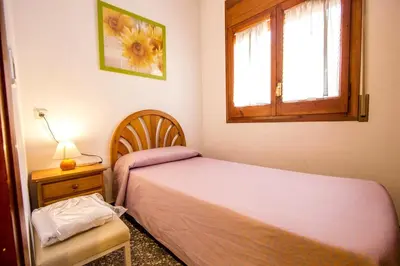 a small bedroom with a bed and a window at Spacious Apartment in Canyelles with Private Pool in Canyelles