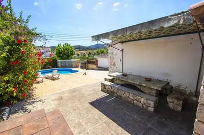 a patio with a bench and a swimming pool at Spacious Apartment in Canyelles with Private Pool in Canyelles