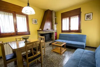 a living room with a blue couch and a table at Spacious Apartment in Canyelles with Private Pool in Canyelles