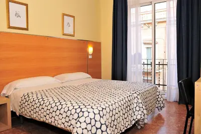 a bedroom with a bed and a large window at Hostal Bejar in Barcelona