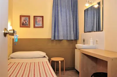 a bathroom with a sink and a counter with a stool at Hostal Bejar in Barcelona