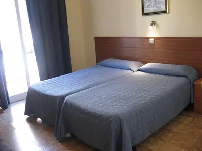 a bedroom with a large bed with a wooden headboard at Hostal Bejar in Barcelona