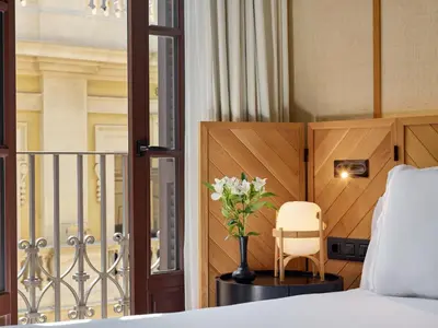 a bedroom with a bed and a vase of flowers at H10 Madison 4* Sup in Barcelona