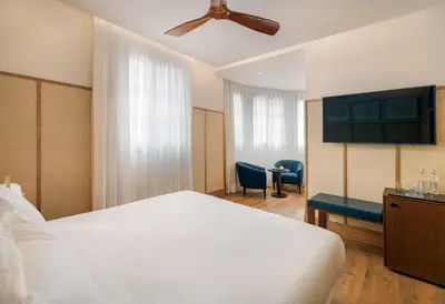 a bedroom with a white bed and a ceiling fan at H10 Madison 4* Sup in Barcelona