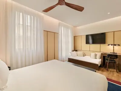 a hotel room with two beds and a flat screen tv at H10 Madison 4* Sup in Barcelona