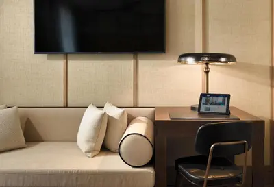 a hotel room with a couch and a desk with a lamp at H10 Madison 4* Sup in Barcelona