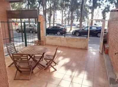 a patio with a table and chairs and a parking lot at Casa Carmen Barcelona in El Prat de Llobregat