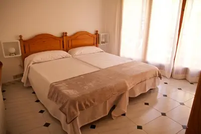 a bedroom with a large bed with a wooden headboard at Casa Pintor in Sant Sadurní dʼAnoia