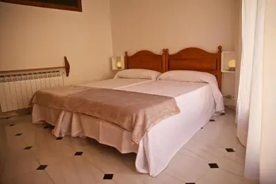 a bedroom with a large bed with white sheets at Casa Pintor in Sant Sadurní dʼAnoia
