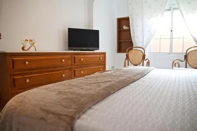 a bedroom with a bed and a dresser with a television at Casa Pintor in Sant Sadurní dʼAnoia