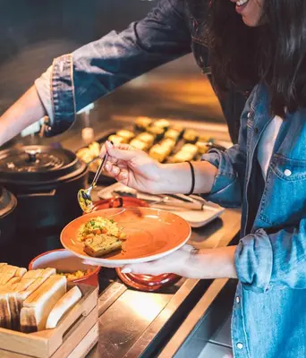 a woman is holding a plate of food at Hotel Rec Barcelona - Adults Only in Barcelona
