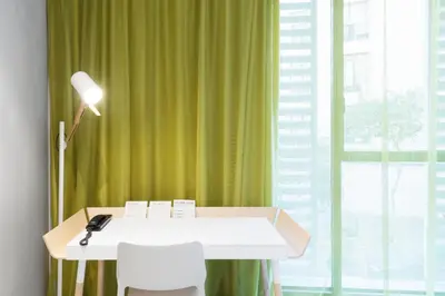 a desk with a lamp and a green curtain at Hotel Rec Barcelona - Adults Only in Barcelona
