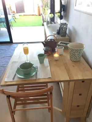 a wooden table with a glass of wine on top of it at Beach flat with garden in Castelldefels