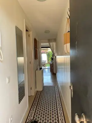 a hallway with a tile floor in a house at Beach flat with garden in Castelldefels