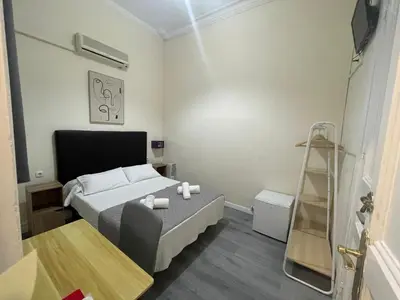 a small bedroom with a bed and a ladder at Hostal Balmes Centro in Barcelona