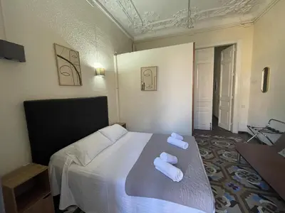 a bedroom with a bed with two towels on it at Hostal Balmes Centro in Barcelona
