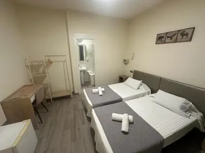 a hotel room with two beds and a bathroom at Hostal Balmes Centro in Barcelona