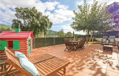 a patio with a table and chairs and a house at Nice Home In St Cebrià De Vallalta in Sant Cebrià de Vallalta