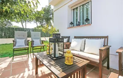 a patio with a couch and two chairs and a table at Nice Home In St Cebrià De Vallalta in Sant Cebrià de Vallalta