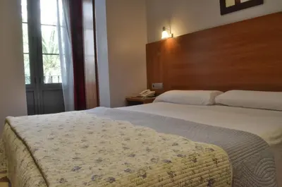 a bedroom with a large bed with a wooden headboard at Ciudad Condal Hostal - Paseo de Gracia in Barcelona