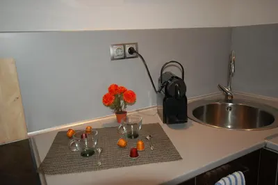 a kitchen counter with a sink and some oranges on a table at Sitges Apartment in Sitges