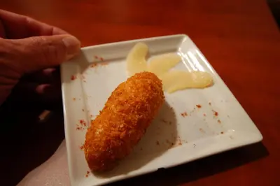 a person holding a plate with a piece of food at Sitges Apartment in Sitges