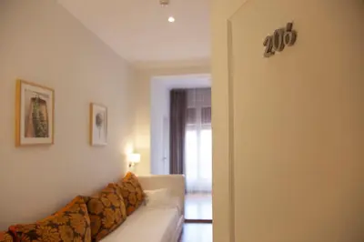 a living room with a couch and a sign on the wall at Hostal Goya in Barcelona