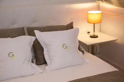 a bed with white pillows and a table with a lamp at Hostal Goya in Barcelona
