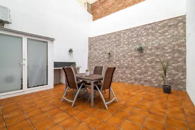 a patio with a table and chairs on a tile floor at Luxury Beach Apartment, next to the sea in Premiá de Mar