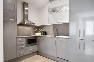 a kitchen with white cabinets and stainless steel appliances at Fisa Rentals Gran Via Apartments in Barcelona