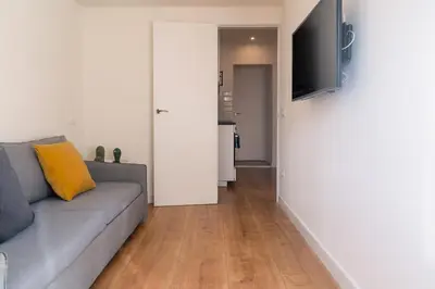 a living room with a couch and a flat screen tv at Vibe Apartments by Olala Homes in Hospitalet de Llobregat