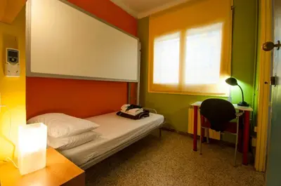 a small room with a bed and a window at Studio Hostel in Barcelona
