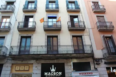 a tall building with balconies and flags on it at Pensión Arosa in Barcelona