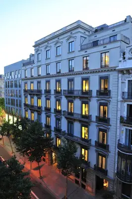 a large blue building with its lights on at Alma Barcelona GL in Barcelona