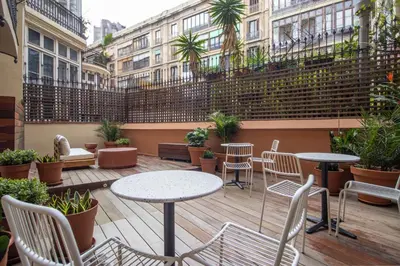 a patio with tables and chairs and plants at Storni Barcelona by Forget me not in Barcelona
