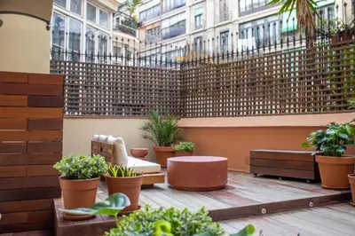 a patio with a chair and potted plants and a fence at Storni Barcelona by Forget me not in Barcelona