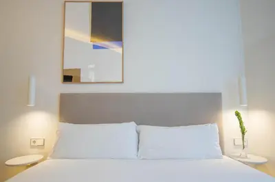 a bedroom with a white bed with two white tables at Storni Barcelona by Forget me not in Barcelona