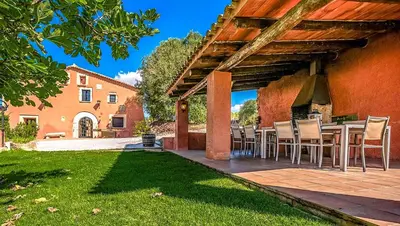 a patio with a table and chairs and a building at Catalunya Casas Country Chateau for 22 persons - close to Sitges! in Les Masuques