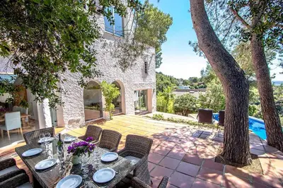 a patio with a table and chairs and a pool at Catalunya Casas Majestic Villa and Views , 30km to Barcelona in Corbera de Llobregat